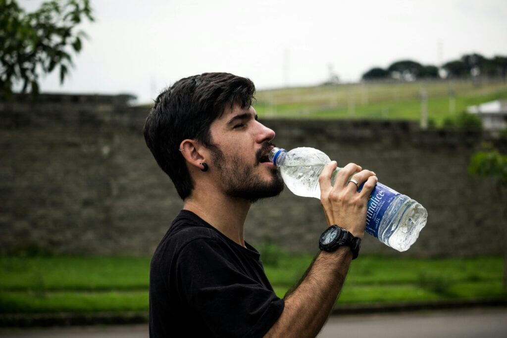 guy drinking water because of coffee dehydration